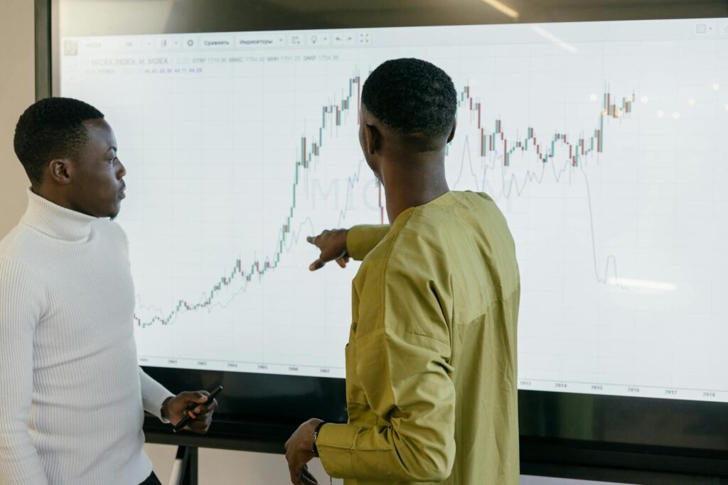 Two professionals discussing financial trends of Energy markets after SAWEM, on a graph at the office.